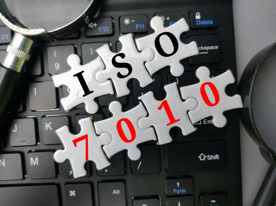 Top view puzzle and magnifying glass with the word ISO 7010